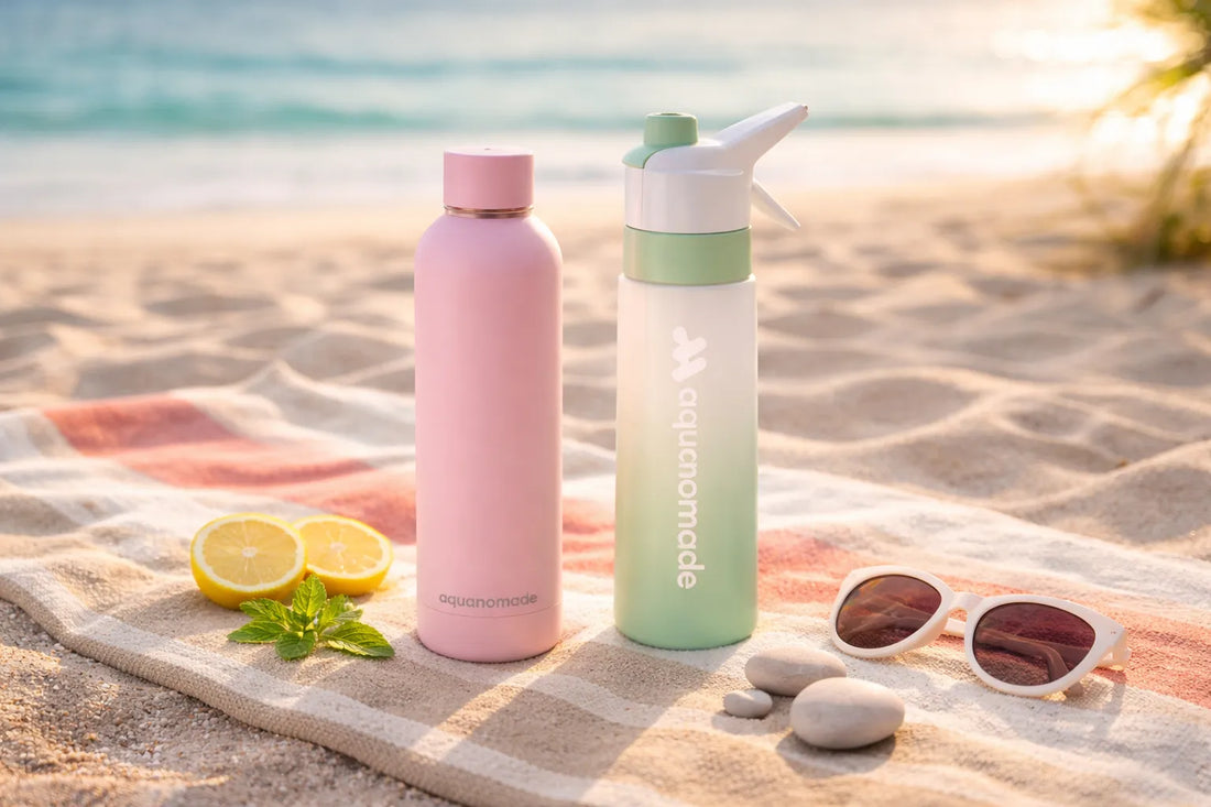 Gourde-isotherme-rose-et-gourde-brumisateur-verte-Aquanomade-posees-sur-une-serviette-de-plage-au-coucher-du-soleil-accessoires-hydratation-ete
